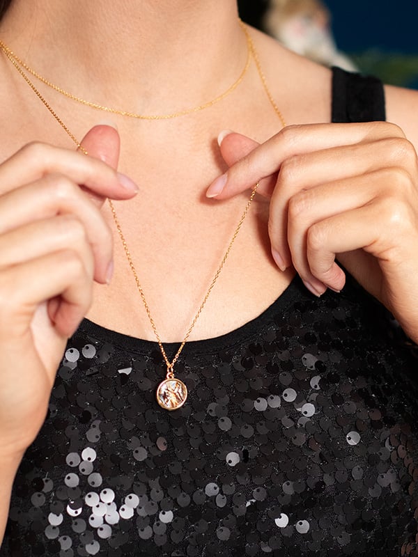 model wearing black sparkly top and paua pearl necklace